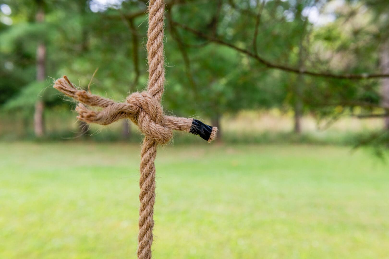 A rope tied to a wooden pole with a pencil stuck in it.