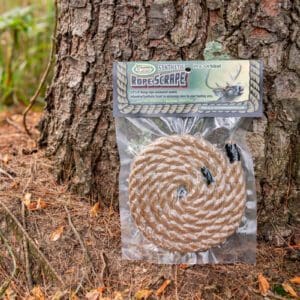 A bag of rope sitting on the ground next to a tree.