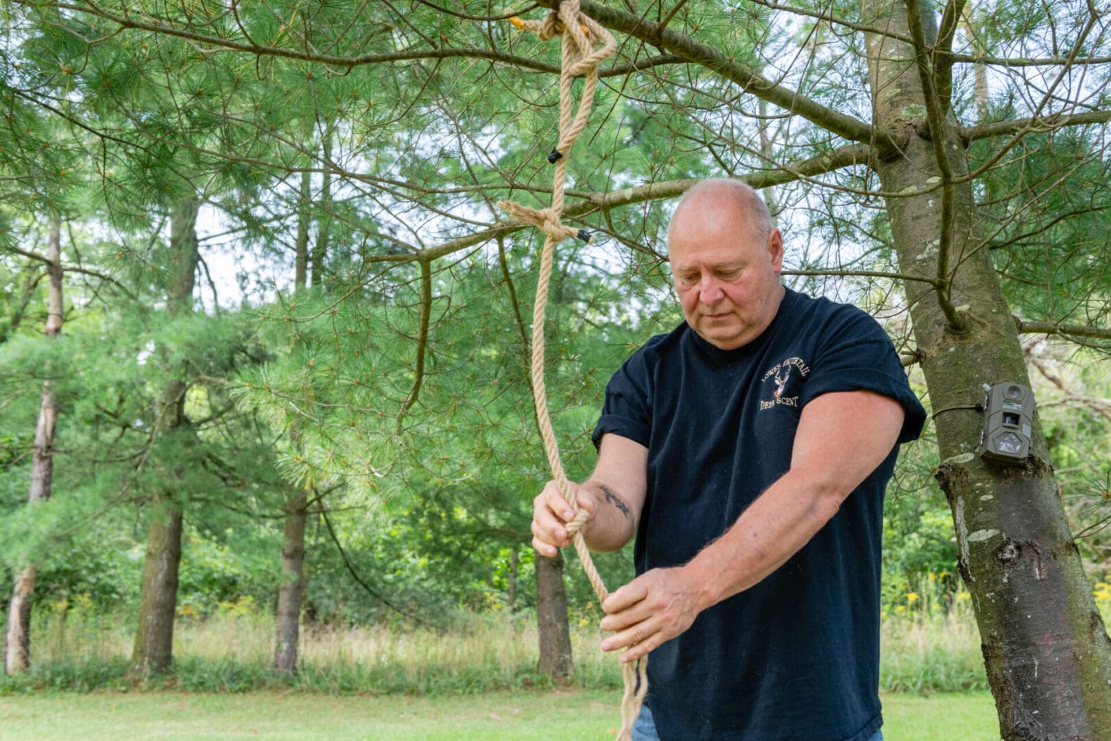 A man holding onto a long stick in the woods